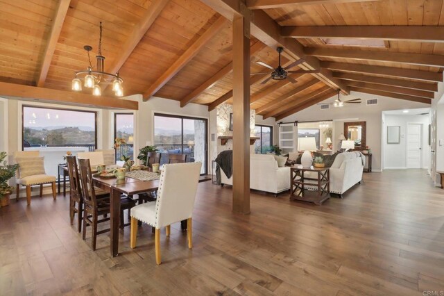 dining room featuring beam ceiling, a wealth of natural light, and dark wood-type flooring