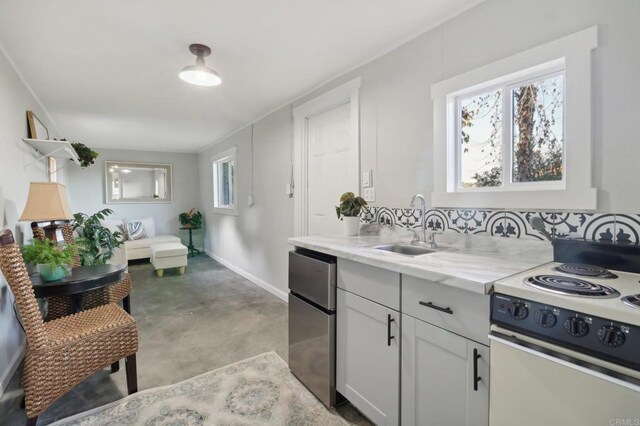 kitchen featuring white cabinets, white electric range oven, light stone counters, and a healthy amount of sunlight