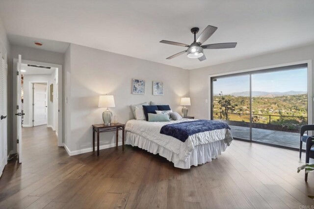 bedroom with hardwood / wood-style flooring, ceiling fan, a mountain view, and access to outside