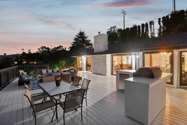 deck at dusk featuring an outdoor living space