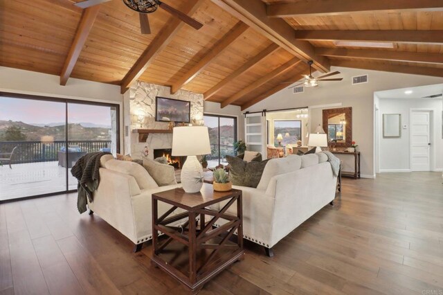 living room featuring plenty of natural light, a barn door, and dark wood-type flooring