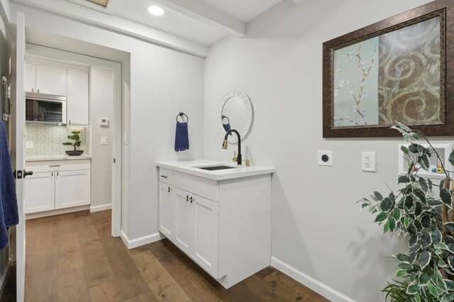 bathroom with beam ceiling, decorative backsplash, vanity, and hardwood / wood-style flooring