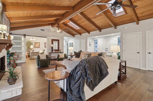 living room with ceiling fan, wooden ceiling, dark wood-type flooring, vaulted ceiling with beams, and a barn door