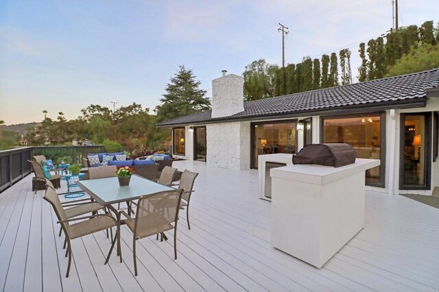 deck at dusk featuring outdoor lounge area