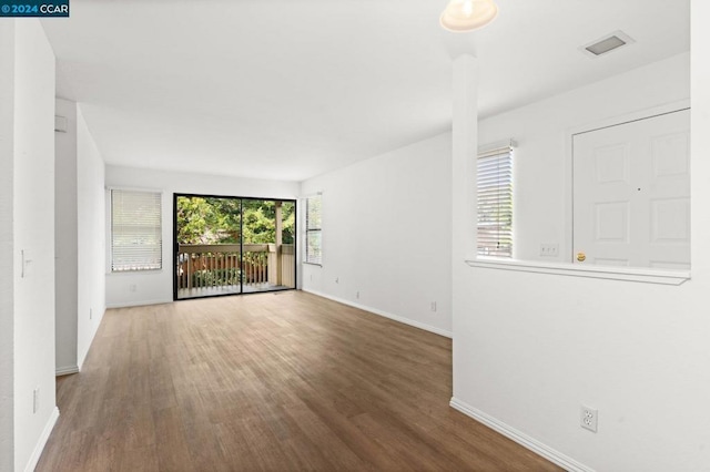 spare room with hardwood / wood-style floors and a healthy amount of sunlight