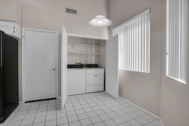 clothes washing area with separate washer and dryer and light tile patterned floors