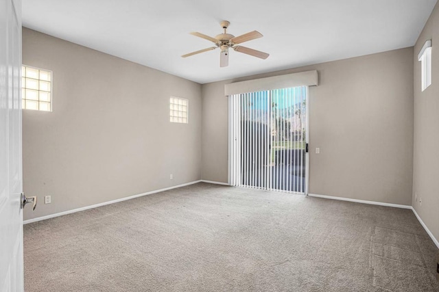 carpeted spare room featuring ceiling fan and a wealth of natural light