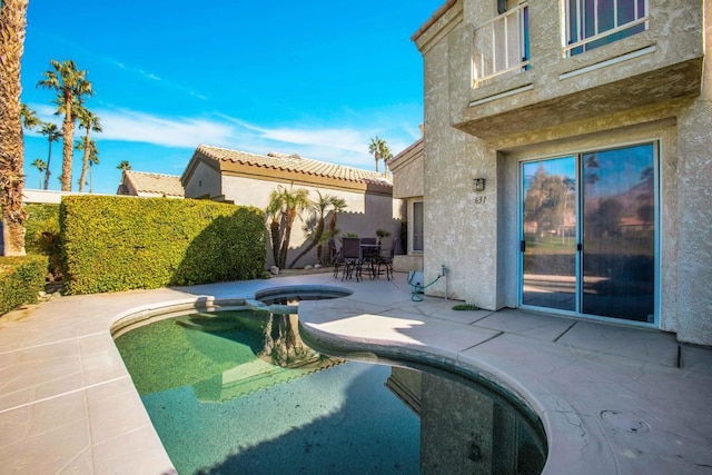 view of swimming pool featuring an in ground hot tub and a patio