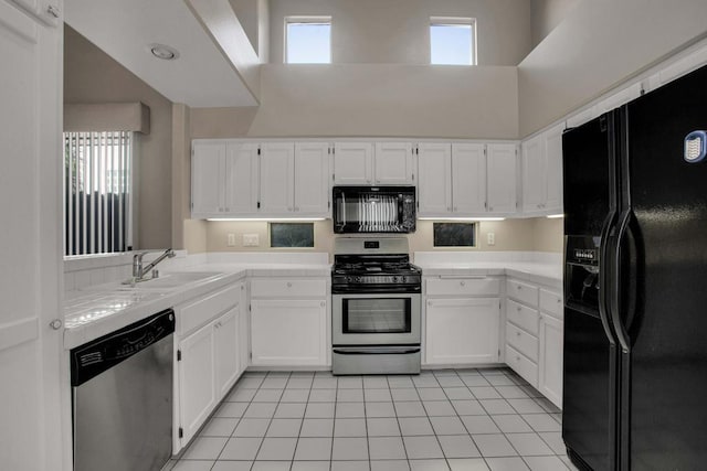 kitchen featuring a high ceiling, sink, a healthy amount of sunlight, and black appliances