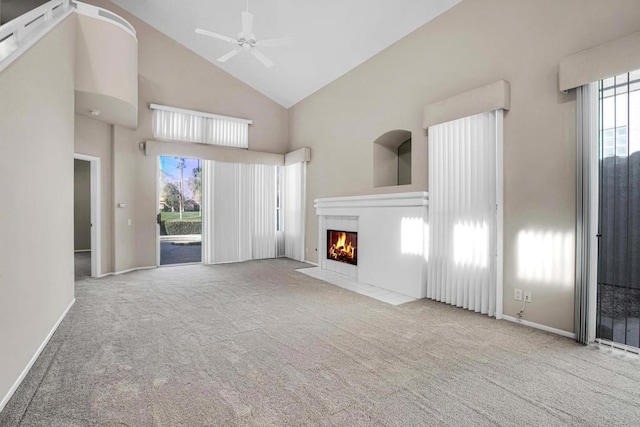 unfurnished living room featuring light colored carpet, high vaulted ceiling, and ceiling fan