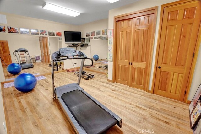 exercise room with wood-type flooring