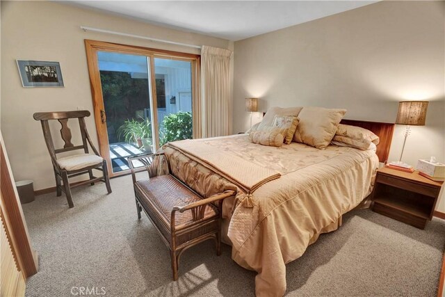 bedroom featuring access to outside, light colored carpet, and wooden walls