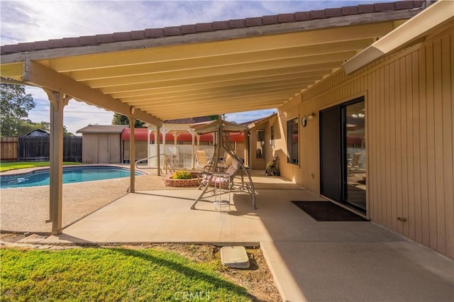 view of patio featuring a fenced in pool and a storage shed