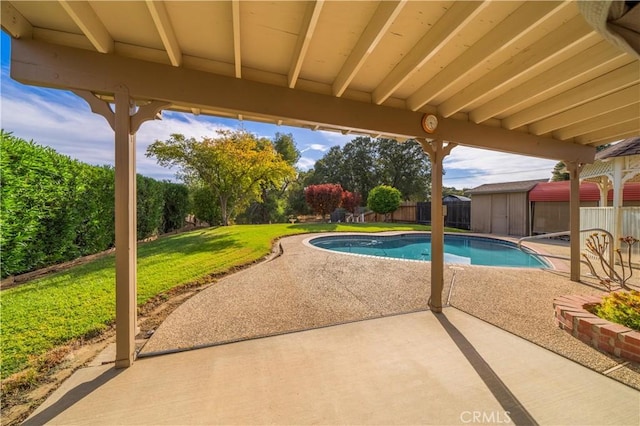 view of pool featuring a yard, a patio, and a storage shed