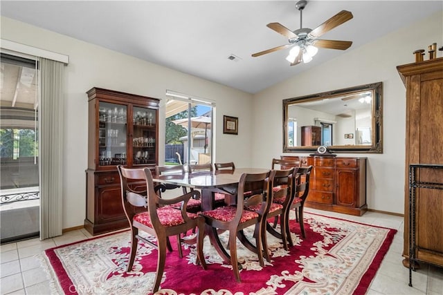 tiled dining space with vaulted ceiling and ceiling fan