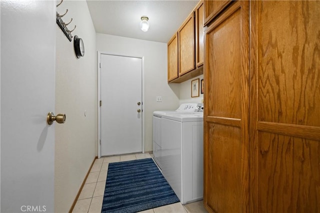 laundry room with light tile patterned flooring, cabinets, and washing machine and dryer