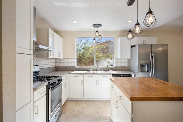 kitchen featuring stainless steel appliances, sink, white cabinetry, butcher block counters, and range hood