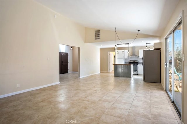 kitchen with backsplash, wall chimney exhaust hood, stainless steel appliances, a center island, and hanging light fixtures