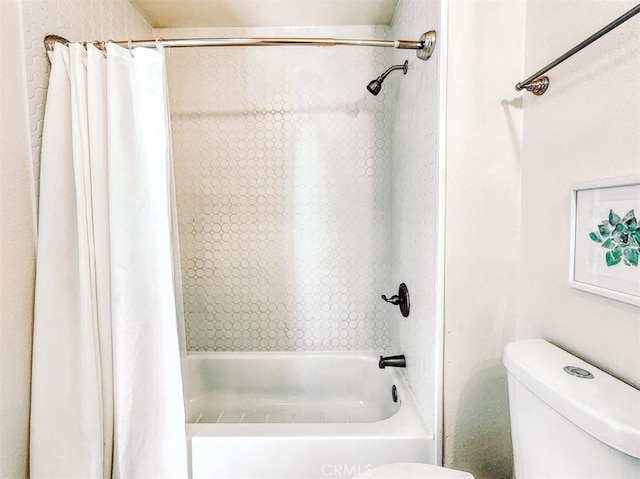 bathroom featuring shower / tub combo and toilet