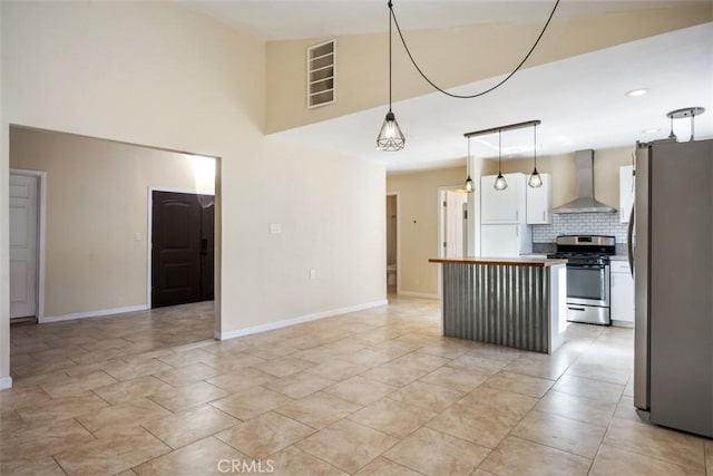 kitchen with backsplash, wall chimney range hood, decorative light fixtures, butcher block counters, and stainless steel appliances