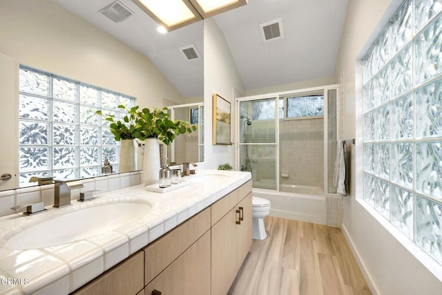 full bathroom featuring plenty of natural light, wood-type flooring, lofted ceiling, and enclosed tub / shower combo