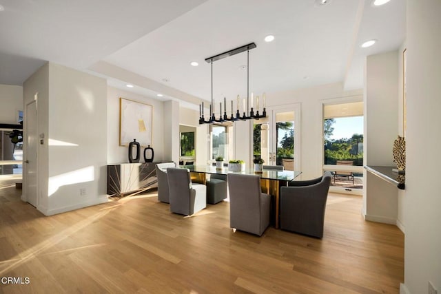 dining space featuring light hardwood / wood-style floors and an inviting chandelier