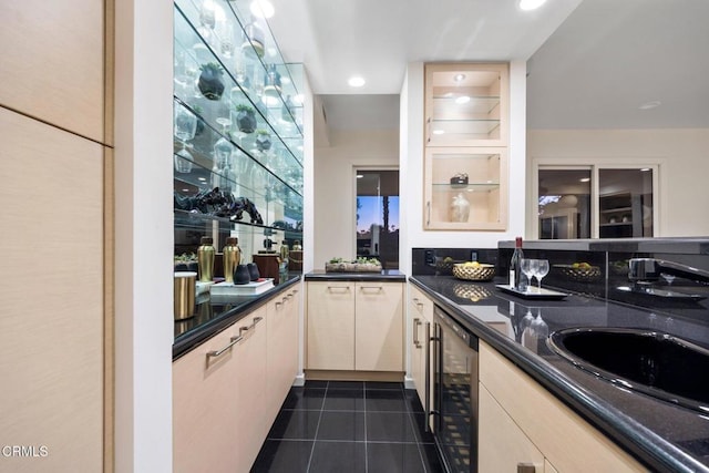 kitchen featuring dark tile patterned flooring, beverage cooler, and sink