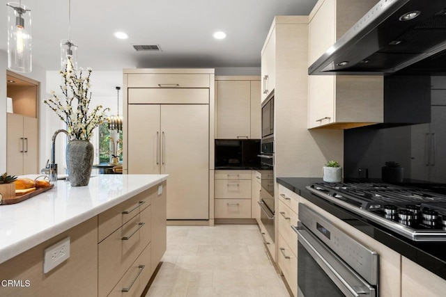 kitchen featuring ventilation hood, sink, hanging light fixtures, built in appliances, and cream cabinetry