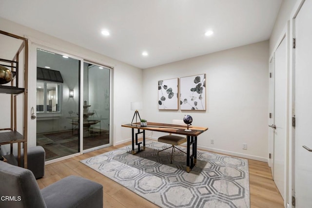 home office with light hardwood / wood-style floors