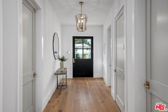 entrance foyer with light hardwood / wood-style flooring and a notable chandelier