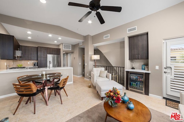 tiled living room featuring ceiling fan, lofted ceiling, sink, and wine cooler