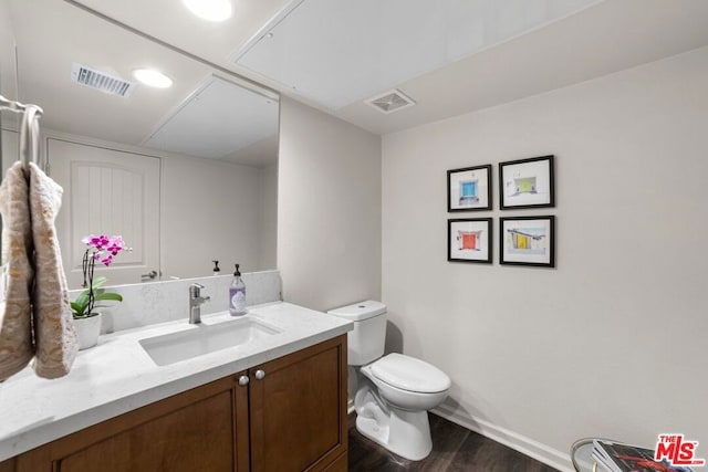 bathroom featuring toilet, vanity, and hardwood / wood-style flooring