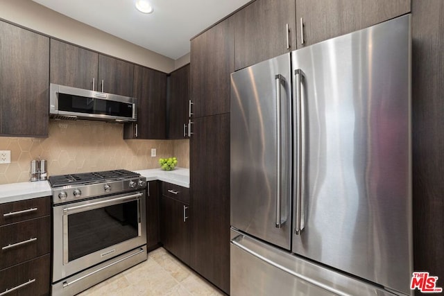 kitchen with light tile patterned floors, dark brown cabinetry, backsplash, and appliances with stainless steel finishes