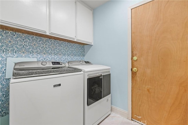 laundry area with separate washer and dryer and cabinets