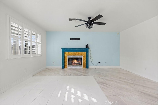 unfurnished living room featuring a tiled fireplace and ceiling fan