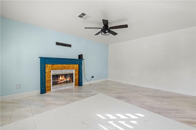 unfurnished living room featuring a tiled fireplace and ceiling fan