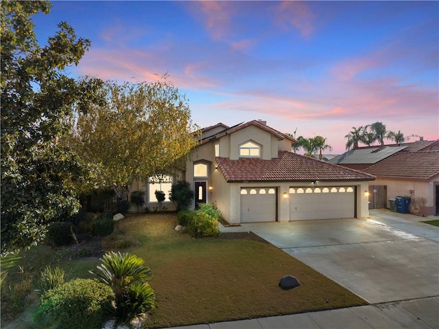 view of front of property with a yard and a garage