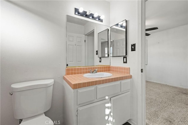 bathroom featuring vanity, toilet, and ceiling fan