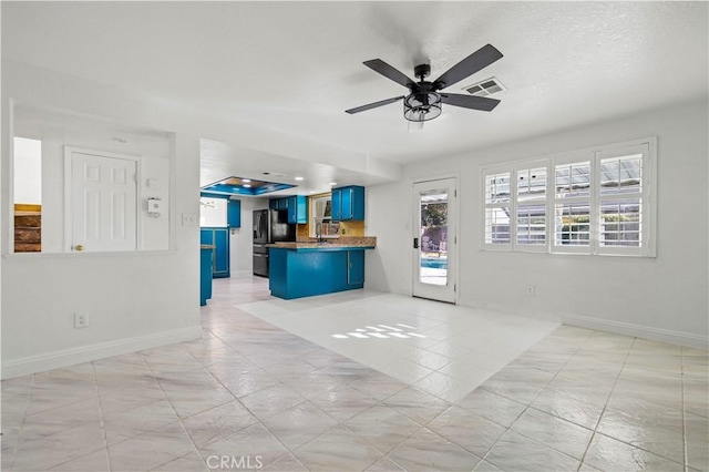 kitchen with kitchen peninsula, a breakfast bar, blue cabinets, ceiling fan, and stainless steel fridge with ice dispenser