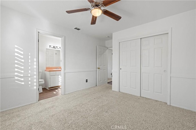 unfurnished bedroom featuring carpet, connected bathroom, a closet, and ceiling fan