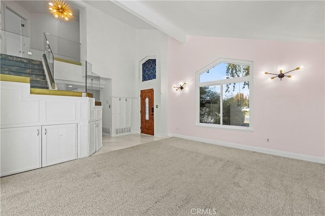 unfurnished living room featuring light carpet, high vaulted ceiling, and beamed ceiling