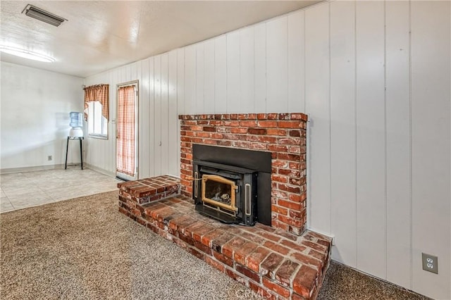 details with a wood stove, wood walls, and carpet floors