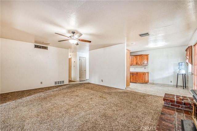 unfurnished living room with ceiling fan and light carpet