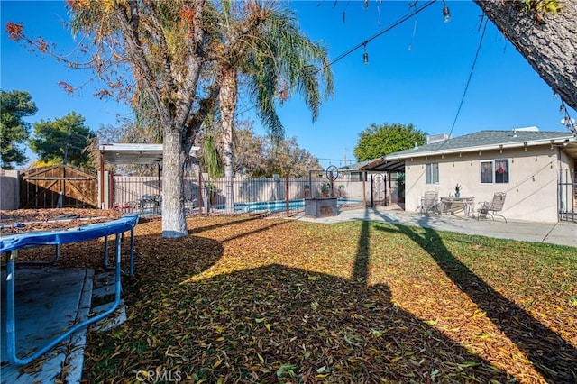 view of yard featuring a patio and a trampoline