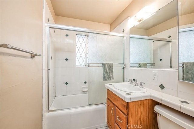 full bathroom with tasteful backsplash, vanity, enclosed tub / shower combo, and toilet