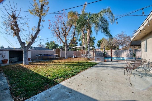 view of yard featuring a fenced in pool, a trampoline, and a patio