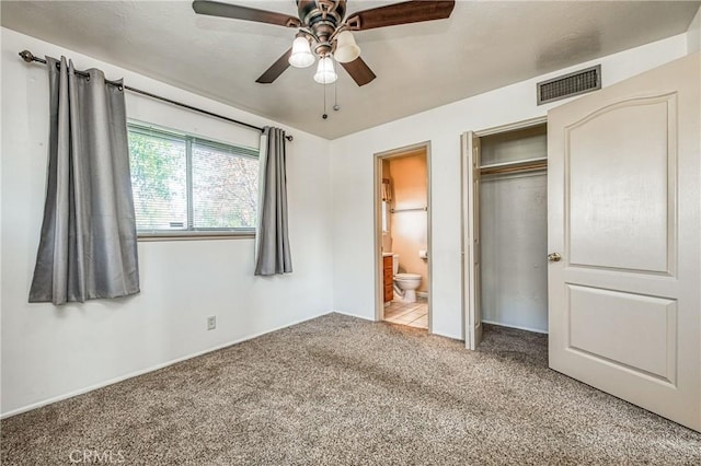 unfurnished bedroom with light carpet, a closet, ensuite bath, and ceiling fan