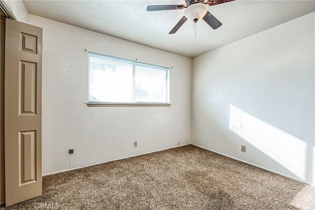 carpeted empty room featuring ceiling fan