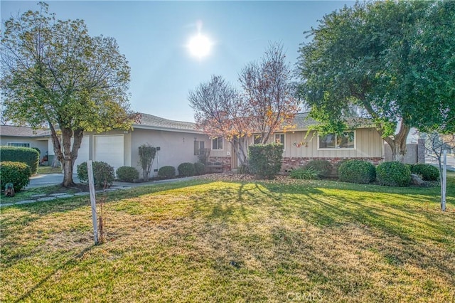 ranch-style home with a garage and a front lawn