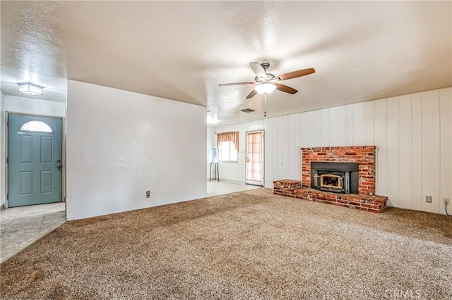 unfurnished living room with light colored carpet, ceiling fan, and wood walls